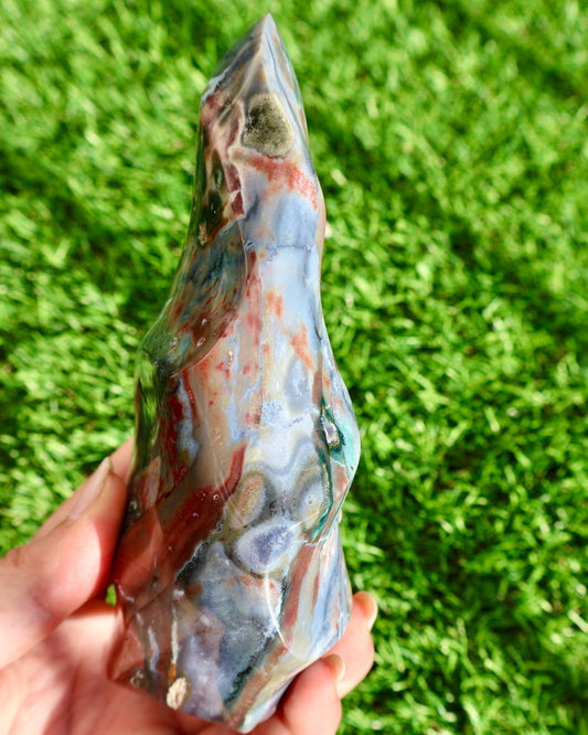 glimmering Ocean Jasper Crystal Flame, Hand Carved Decorative Sculpture, Multicolor 5-6" in studio background